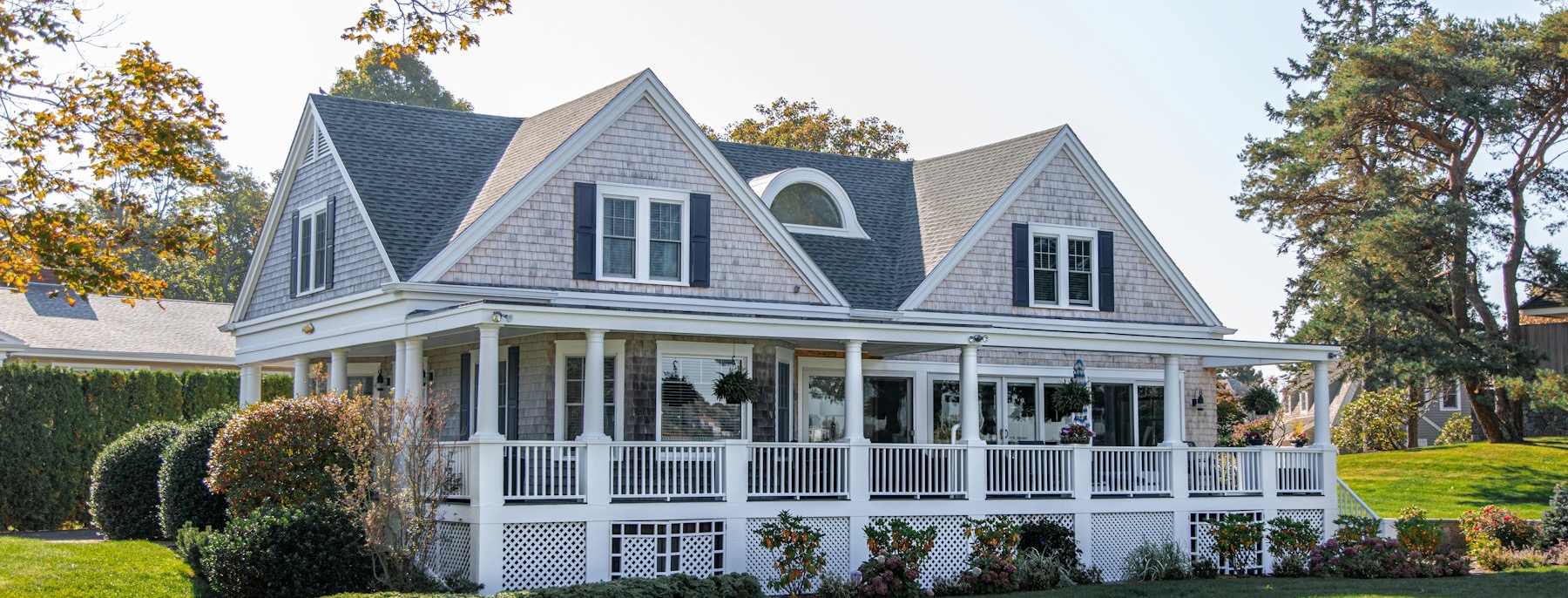 A suburban house with a wraparound porch and front lawn