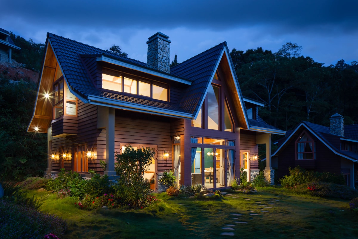 A single-family home at dusk with its lights on
